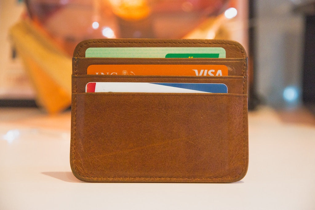 A leather wallet with three credit cards in it. 