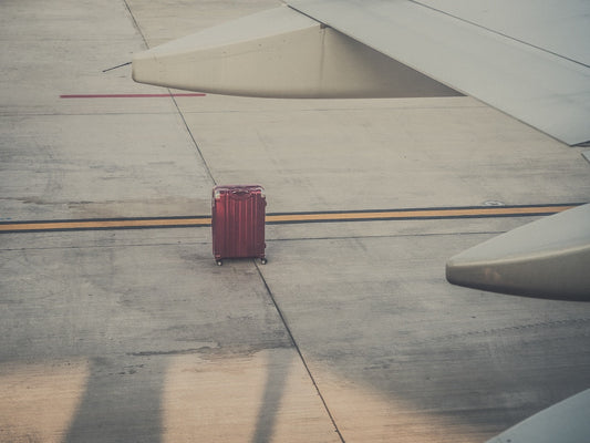 A suitcase left behind under a plane's wing.