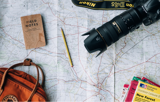 A map laid out with essential travel items on top.